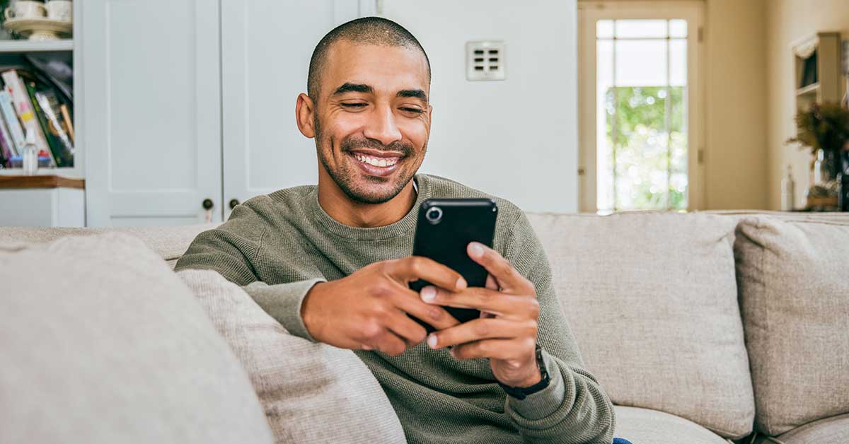 prospective student on phone on couch